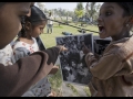 Alisha, Ankada et Payal Rajak rient en se reconnaissant sur l’un des tirages d’une exposition photographique.