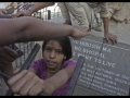 Des enfants jouent au pied du monument commémoratif de la catastrophe.